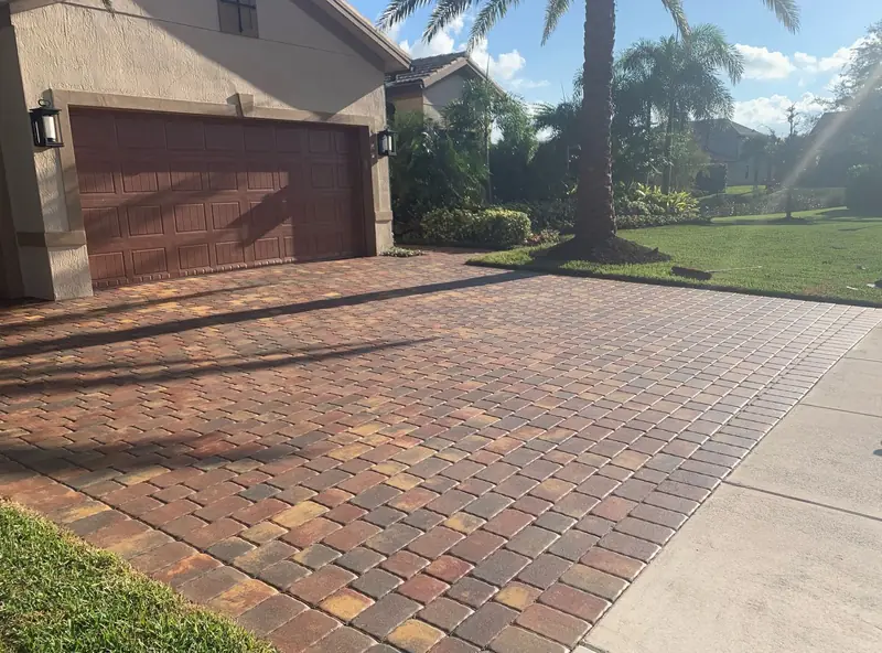 A sealed red and tan paver driveway with a rich finish