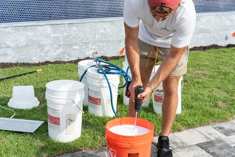 A crew member mixing sealer before application